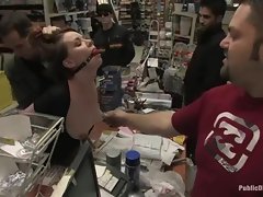 Young redhead is gagged and a dildo is forced into her in sexy shop.